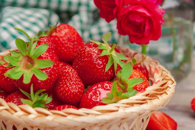 Panier de récolte de fraises sur table en bois se bouchent