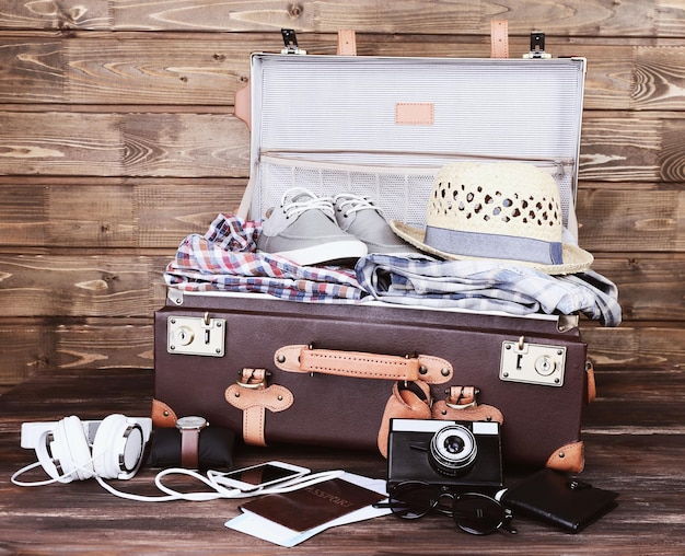 Panier-valise d'articles de vacances sur fond de bois