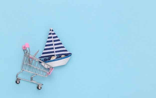 Panier avec un voilier sur fond bleu. Espace de copie. Vue de dessus