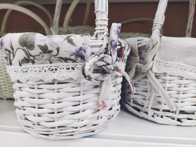 Paniers décoratifs en osier sur une étagère dans un magasin Jolis paniers peints en blanc Sac textile Cadeau élégant pour Pâques Élément de décoration de l'intérieur d'un appartement une maison de campagne ou un jardin de printemps