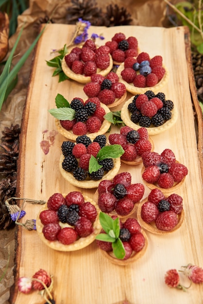 Paniers sablés à la crème de lait caillé et baies sur un tapis en bois