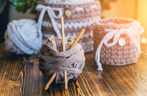 Paniers tricotés sur une table en bois.