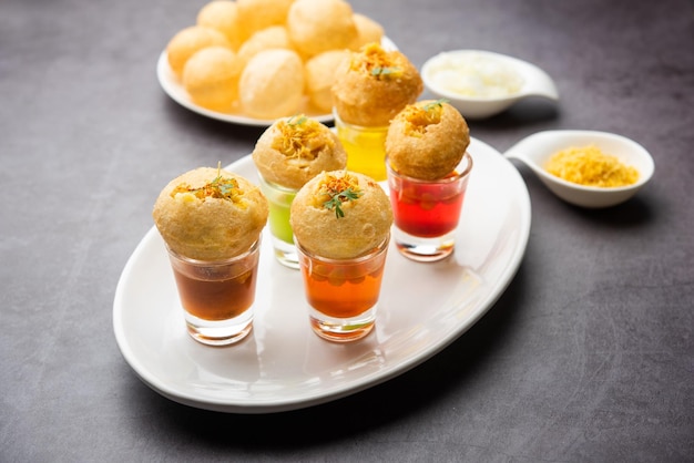 Panipuri shot ou Golgappa Shots différentes saveurs d'eau servies dans de petits verres avec un en-cas indien puri farci