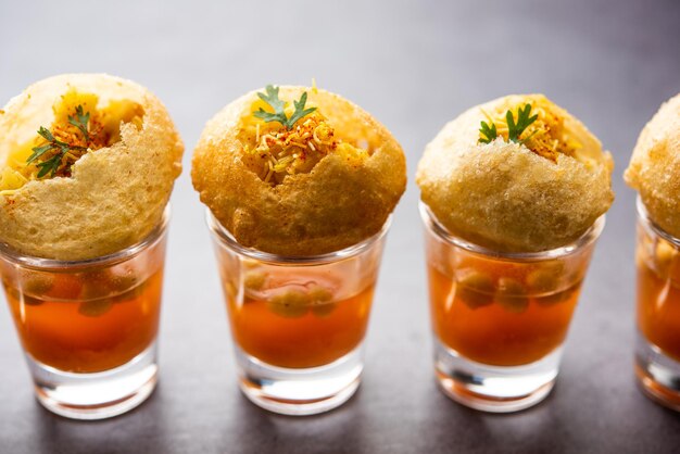 Panipuri shot ou Golgappa Shots différentes saveurs d'eau servies dans de petits verres avec un en-cas indien puri farci