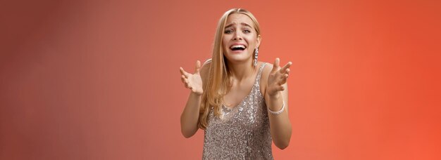 Photo en panique, bouleversée, misérable, au cœur brisé, une fille blonde qui pleure, lève les mains, supplie de ne pas se séparer.