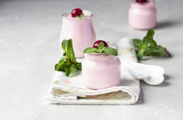 Panna cotta aux cerises avec cerises fraîches et menthe en pots