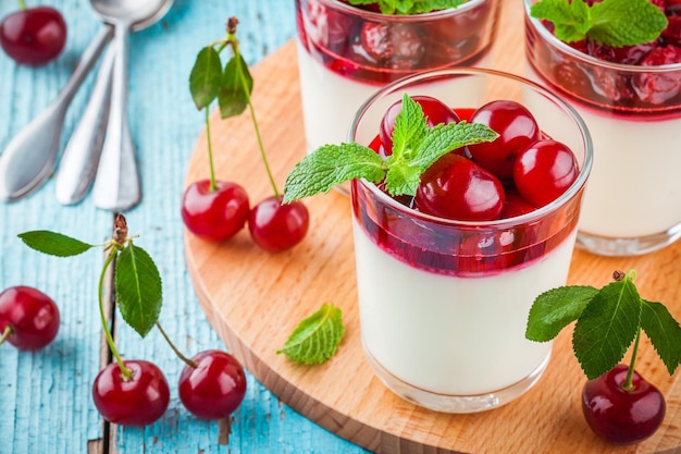 Panna cotta dessert maison avec sauce aux cerises et menthe