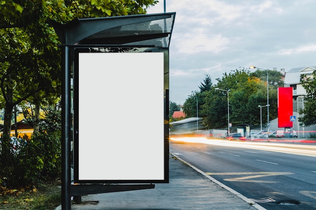 Photo panneau d'affichage à l'abri de l'arrêt de bus avec lumière de piste floue