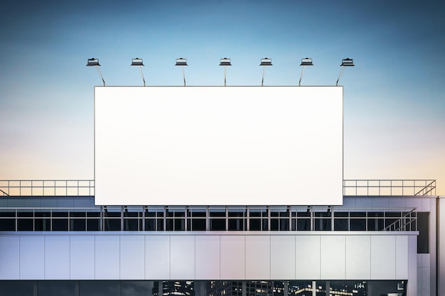 Panneau d'affichage blanc vierge avec projecteurs au-dessus du bâtiment industriel sur fond de ciel du soir maquette de rendu 3D