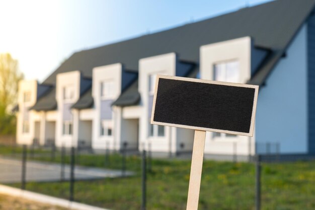 Photo un panneau d'affichage noir blanc contre un appartement, une maison familiale, une maquette vide, un modèle d'étiquette de panneau noir à