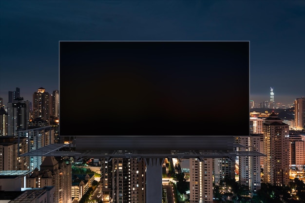 Panneau d'affichage routier noir vierge avec fond de paysage urbain de Kuala Lumpur la nuit Affiche publicitaire de rue maquette rendu 3D Vue de face Concept de marketing pour promouvoir ou vendre une idée ou un produit