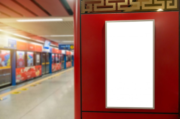 Panneau d'affichage vide blanc ou boîte à lumière publicitaire sur le mur rouge dans la station de métro, publicité, commercial, marketing, concept publicitaire