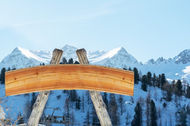 Panneau d'affichage vide pour la publicité extérieure à partir de journaux et d'une planche de bois sur une piste de ski dans le contexte des montagnes. Le concept de publicité, paysage, sport.