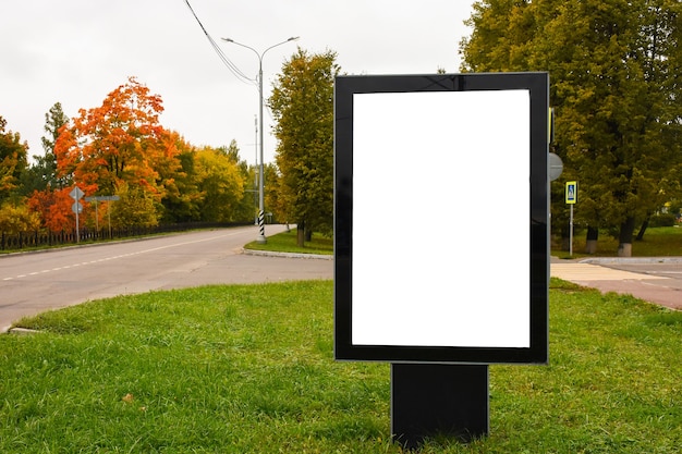 Panneau d'affichage vide vertical dans une rue de la ville un jour d'automne