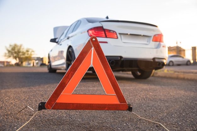 Panneau d'arrêt d'urgence rouge et voiture cassée