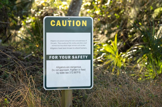 Panneau d'avertissement d'alligators dans le parc d'état de Floride concernant la prudence et la sécurité pendant la marche sur le sentier