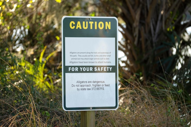 Panneau d'avertissement d'alligators dans le parc d'état de Floride concernant la prudence et la sécurité pendant la marche sur le sentier