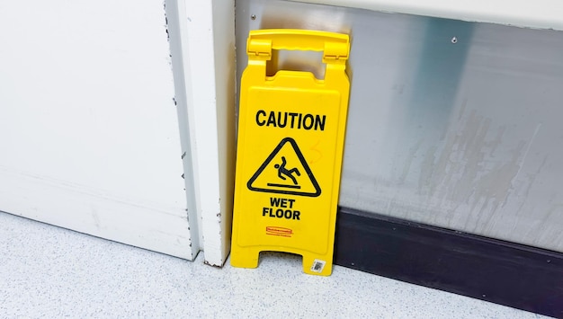 Un panneau d'avertissement jaune est sur une porte qui indique la prudence.