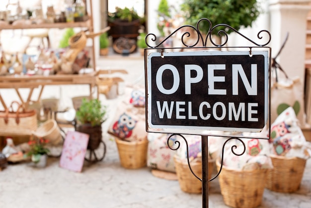 Panneau de bienvenue ouvert à l'extérieur d'une boutique du marché