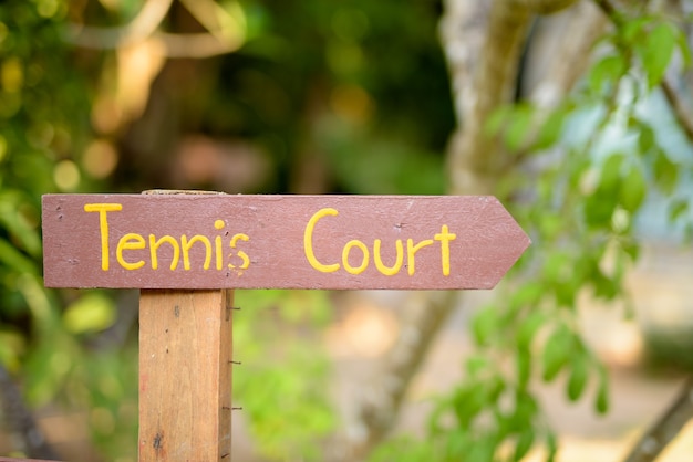 Panneau en bois indiquant le court de tennis