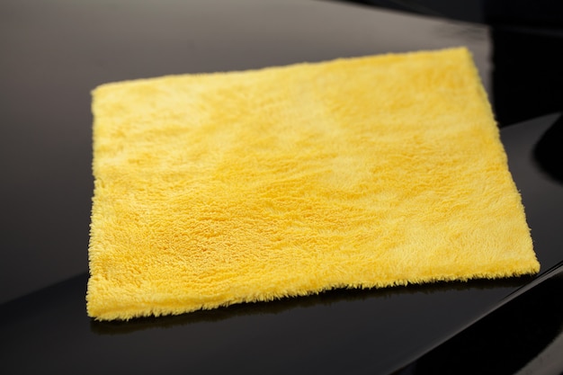 Photo panneau d'essuyage d'une voiture de luxe avec microfibre jaune