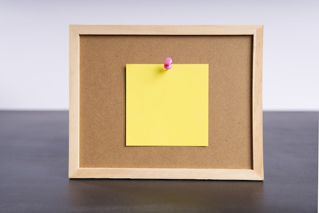 Panneau d'information de bureau avec une feuille de papier jaune attachée avec un espace pour le texte