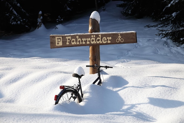 Photo un panneau d'information sur des montagnes couvertes de neige contre le ciel