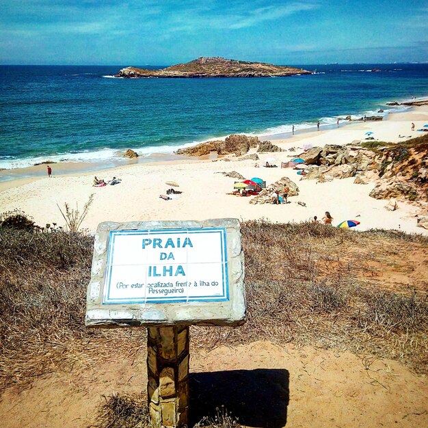 Photo un panneau d'information sur la plage contre le ciel