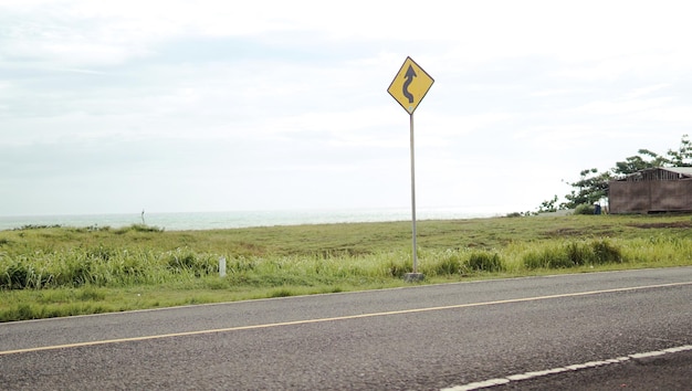 Un panneau jaune sur le bord de la route indique qu'il s'agit d'un virage.