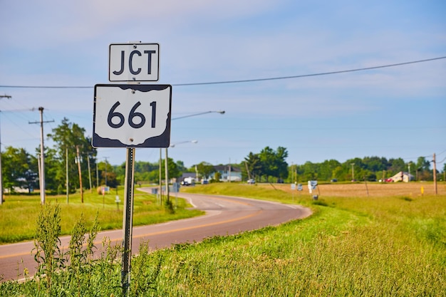 Le panneau JCT 661 à côté de l'autoroute en été avec un ciel bleu et des nuages minces