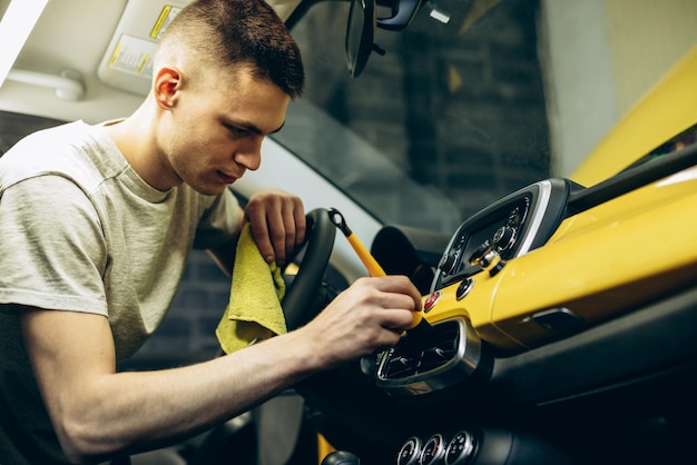 Panneau de nettoyage homme avec brosse à l'intérieur d'une voiture