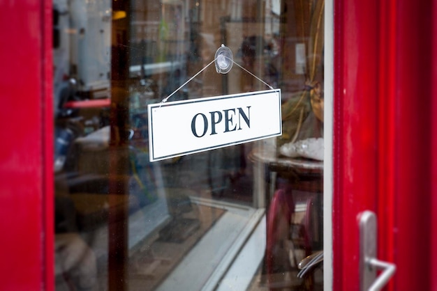 Un panneau d'ouverture vu à travers une porte en verre dans un magasin