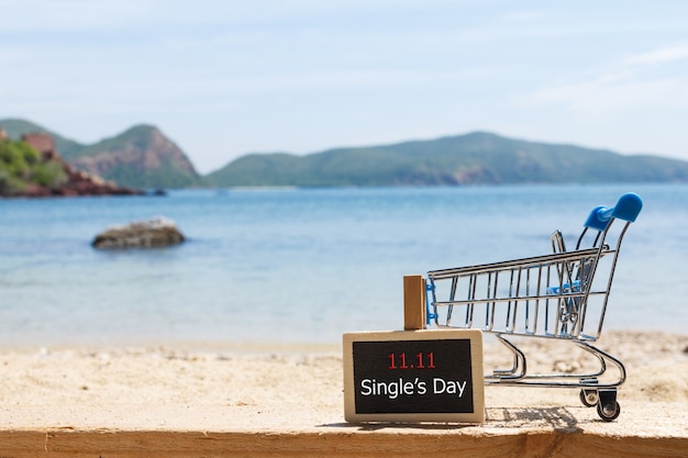 Photo panneau et panier à la plage. achats en ligne de chine. concept de vente de jour unique.