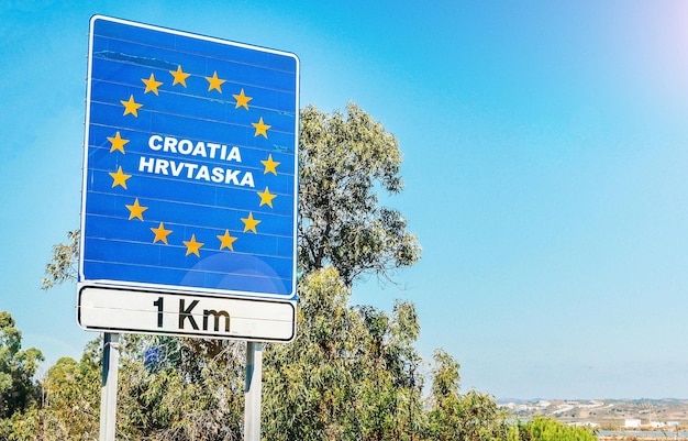 Panneau routier à la frontière d'un pays de l'Union européenne Croatie 1km devant avec ciel bleu copie espace