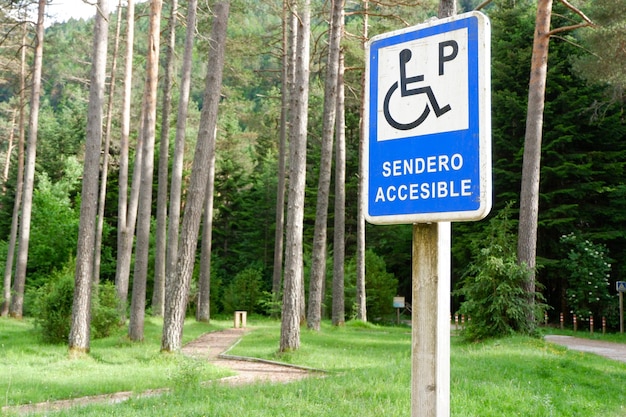 Panneau routier pour un parking accessible dans la forêt à l'extérieur de l'espagnol signifie sentier accessible