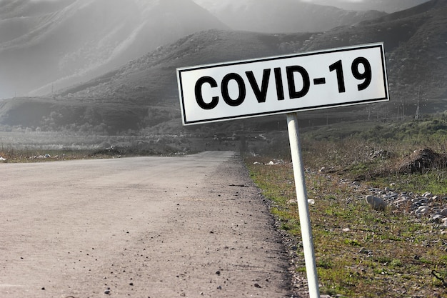 Panneau routier et routier avec mot - Covid-2019. Concept de coronavirus de voyage dangereux.