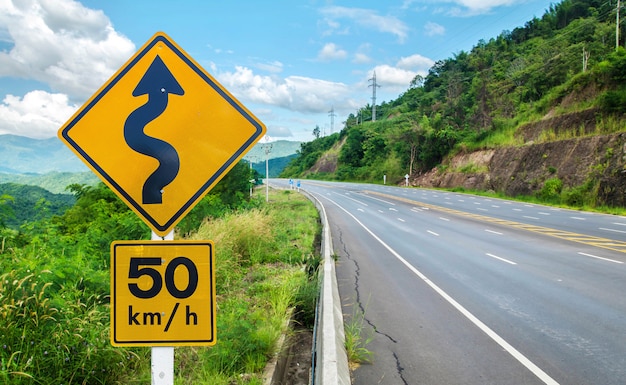 Photo panneau de signalisation d'avertissement sur la route sinueuse de pôle métallique