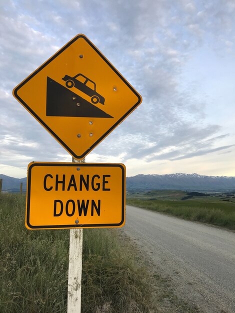 Panneau de signalisation: Bas, panneau de descente raide sur fond jaune.