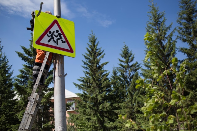 Panneau de signalisation d'installation sur poteau Road worker sets sign