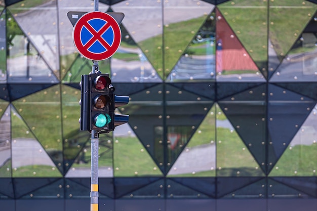 Le panneau de signalisation et sémaphore avec feu rouge sur le gros plan de fond urbain