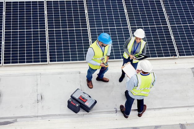 Panneau solaire d'ingénierie et vue de dessus de l'équipe en discussion pour inspection ou installation Énergie propre et solaire durable à partir de cellules photovoltaïques avec des industriels en collaboration sur un site