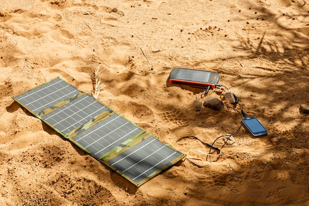 Photo panneau solaire sur le sol et charge le téléphone