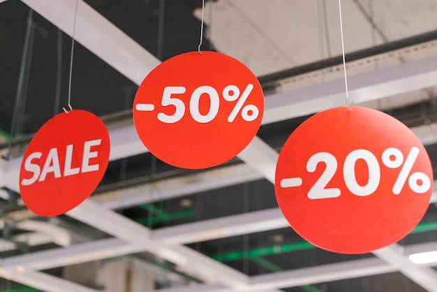 Un panneau de vente avec le prix des réductions % est affiché dans un magasin.