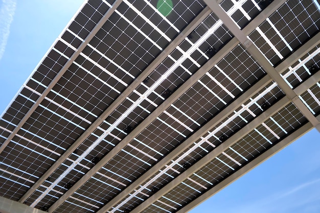 Des panneaux solaires installés au-dessus de l'auvent du parking pour les voitures en stationnement pour une production efficace d'énergie propre