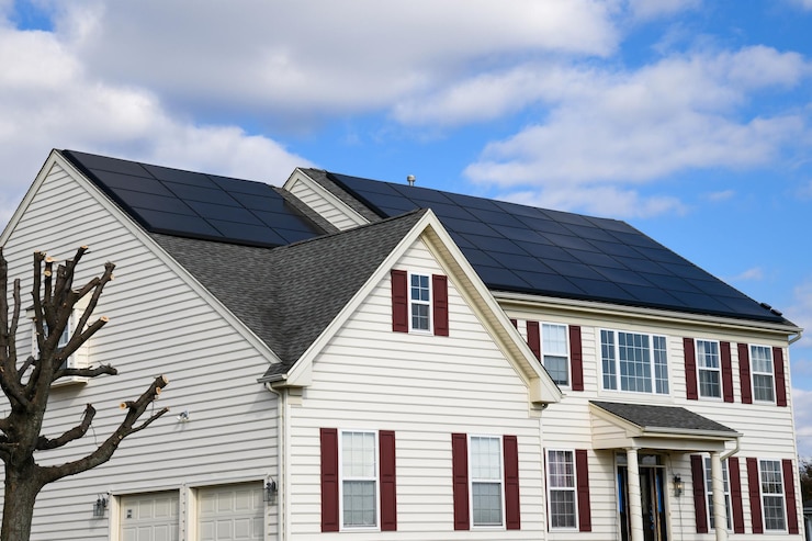 Photo panneaux solaires photovoltaïques efficaces à économie d'énergie verte et renouvelable sur plusieurs toits de maisons de banlieue à pignons