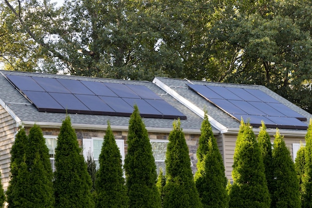 Photo panneaux solaires produisant de l'énergie propre sur le toit d'une maison résidentielle