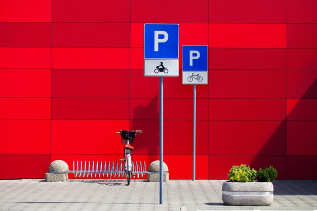 Panneaux de stationnement pour vélos et vélos sur fond de mur rouge