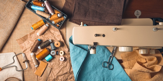 Panorama avec accessoires de couture sur l'arrière-plan d'une machine à coudre floue.