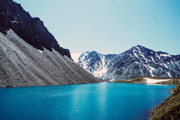 Panorama du magnifique lac bleu dans les montagnes le soir. le fond du lac brille bien sous les rayons du soleil. pierres dans une eau cristalline.