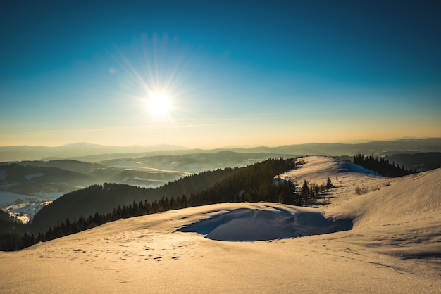 Panorama ensoleillé pittoresque lumineux des pistes de ski sur le fond de la vallée